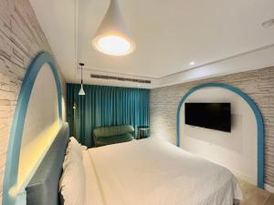 a bedroom with a bed and a flat screen tv at Formosa Motel & Inn in Changhua City