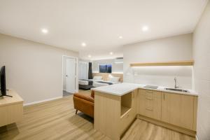 a kitchen and living room with a couch at Takapuna International Motor Lodge in Auckland