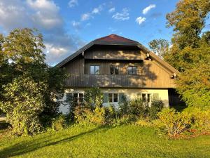 uma grande casa de madeira no topo de um campo verde em Ferienhaus BERGEBLICK DELUXE em Bad Tölz