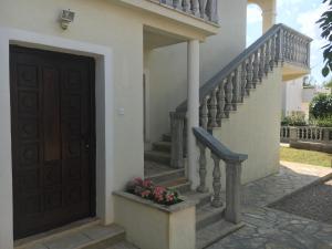 una casa con una puerta y escaleras con flores en Holiday Home 1, en Bibinje