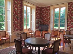 a room with chairs and a table and a tv at Camping Castels Chateau de Chanteloup in La Croix