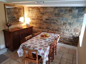 a dining room with a table with a bowl of fruit on it at Mayfield Cottage in Burtree Ford