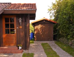 une maison extérieure en bois avec une porte et un hangar dans l'établissement Ferienhaus Stolley, à Silberstedt