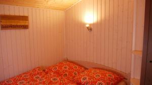 a small room with a bed with a red pillow at Stolley - Ferienhaus mit Garten, Kamin und Sauna in Silberstedt