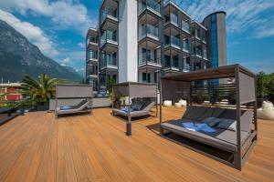 two beds on a deck in front of a building at Lake Front Hotel Mirage in Riva del Garda