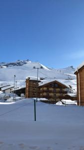 un edificio en la nieve con montañas en el fondo en Chasse neige - Cervinia, en Breuil-Cervinia