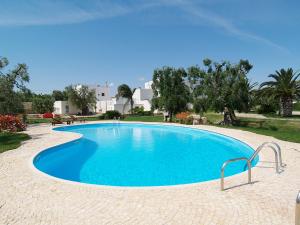 a large blue swimming pool in a resort at Hotel Masseria Tutosa in Ostuni
