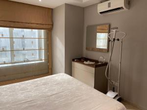 - une chambre avec un lit, un miroir et une fenêtre dans l'établissement Lac Palace Luxury Apartment-2 Bdr, à Tunis