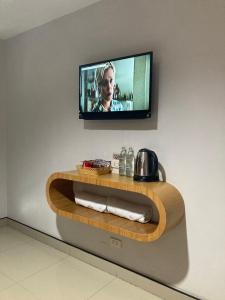 a television on a wall with a wooden shelf at @Me2 Hotel in Phitsanulok