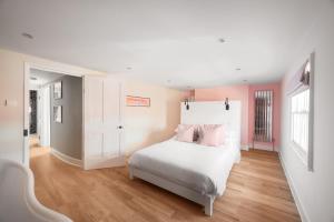 a bedroom with a bed with pink walls and wooden floors at Worthing town house in Worthing