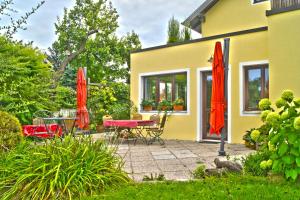 patio z czerwonymi parasolami, stołem i krzesłami w obiekcie Gästezimmer Ilse Brauneis w mieście Mautern