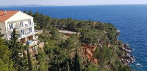 a house on a cliff next to the ocean at Villa Jagoda in Sveta Nedelja