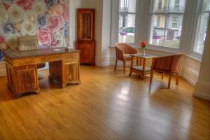 a room with a desk and a table and chairs at Villa Rose in Great Yarmouth