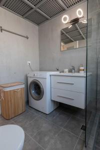 a bathroom with a washing machine and a sink at Athenian Port Luxury Apartment 1/Piraeus Riviera in Piraeus