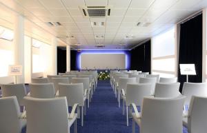 a room with white chairs and a projection screen at Hotel Villa Giulietta in Fiesso dʼArtico