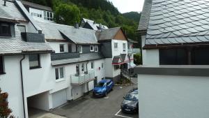 ein blaues Auto, das auf einem Parkplatz zwischen Gebäuden parkt in der Unterkunft Ferienwohnungen Mittendrin in Willingen