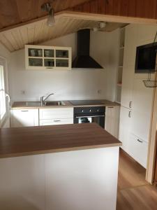 a kitchen with white cabinets and a counter top at Stolley - Ferienhaus mit Garten, Kamin und Sauna in Silberstedt