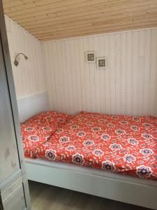 a bed with a red comforter in a room at Stolley - Ferienhaus mit Garten, Kamin und Sauna in Silberstedt