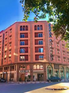 un gran edificio de ladrillo rojo en una calle de la ciudad en Hotel Al Kabir, en Marrakech