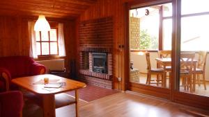 a living room with a fireplace and a table at Stolley - Ferienhaus mit Garten, Kamin und Sauna in Silberstedt