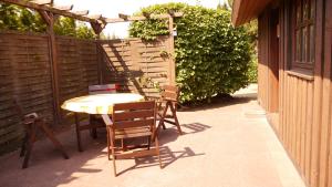 a patio with a table and chairs and a fence at Stolley - Ferienhaus mit Garten, Kamin und Sauna in Silberstedt