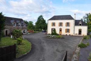 a large white house with a driveway at La Grande Malardiere in Saint-Georges-Buttavent