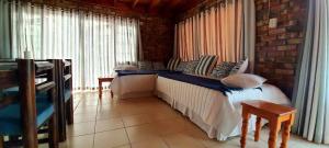 a bedroom with a bed in a room with windows at Cozy Cottage +/- 500m from the beach in Cape Town