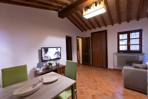 a living room with a table and green chairs at IL Rustichello in Pisa