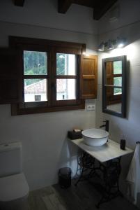 a bathroom with a white sink and two windows at El Molín de La Vega Agroturismo in Ribadesella