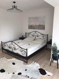 - une chambre dotée d'un grand lit avec un cadre noir dans l'établissement Gemütliches Bergappartement mit Weitblick, à Bad Bentheim