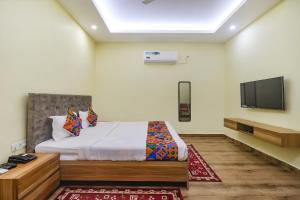 a bedroom with a bed and a flat screen tv at FabExpress Le Gardenia in Patna