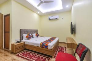 a bedroom with a bed and a ceiling fan at FabExpress Le Gardenia in Patna