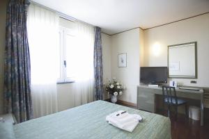 a hotel room with a bed with two towels on it at Hotel Royal in Fermo