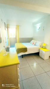 ファタガにあるCasa Reyes Fataga Apta Reyesのベッドルーム1室(ベッド1台、黄色いテーブル付)
