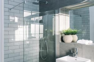 een badkamer met een glazen douche en een wastafel bij ALTIDO Bold and Spacious 1bed home, near Haymarket train station in Edinburgh