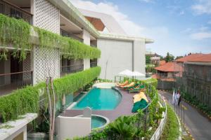 an external view of a building with a swimming pool at Beachwalk Residence in Kuta