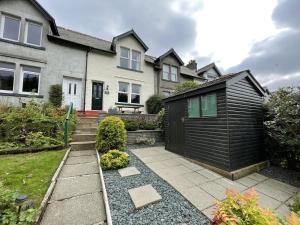 a house with a black shed in the yard at Glenderamackin Cottage in Threlkeld