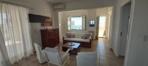 a living room with a couch and a table at Breezy Beach House in Agia Marina Mikrolimanou