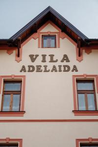 una señal en el lateral de un edificio con ventanas en Villa Adelaida, en Sarajevo