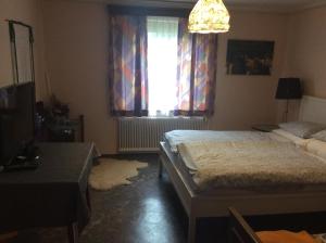 1 dormitorio con 2 camas, TV y ventana en Mooswirt, en Ranten