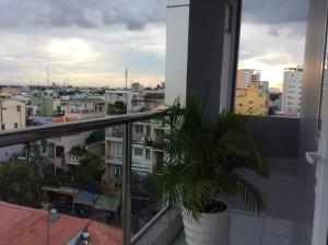 una planta en una olla en un balcón con una ciudad en Hau Giang 2 Hotel, en Can Tho