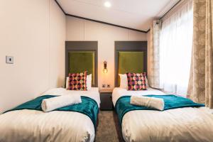 2 aparte bedden in een kamer met een raam bij Bushmills Lodge with Hot Tub in Thornton