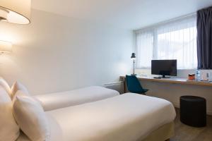 Un pat sau paturi într-o cameră la Comfort Hotel ORLY-RUNGIS