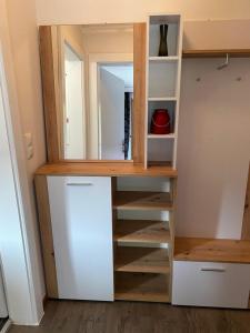 un armario con estanterías y un espejo en una habitación en Apartment GRANAT en Sankt Oswald