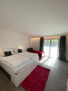 a bedroom with a white bed and a red rug at Apartment GRANAT in Sankt Oswald