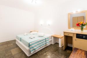 a bedroom with a bed and a desk and a mirror at Paradise Beach Resort in Paradise Beach