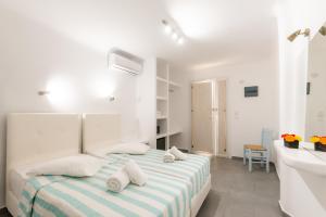 a white bedroom with a bed and a sink at Paradise Beach Resort in Paradise Beach