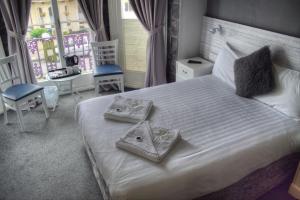 a hotel room with a bed, chair, and nightstand at Villa Rose in Great Yarmouth
