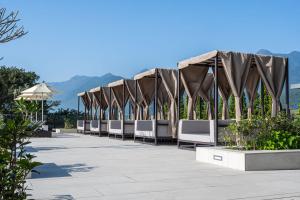 eine Reihe von Stühlen und Sonnenschirmen auf einer Terrasse in der Unterkunft Lakeshore Hotel Hualien Taroko in Shunan