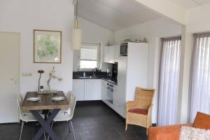 a kitchen with a table and a dining room at Huinerhofje 2 - Vrijstaand met grote omheinde tuin, rust, privacy en nabij bossen in Putten